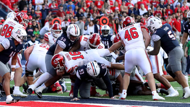 Nov 18, 2023; Tucson, Arizona, USA; Utah Utes quarterback Bryson Barnes (16) dives into the end zone for a touchdown against Arizona Wildcats defensive lineman Jacob Kongaika (93) during the second half at Arizona Stadium. Mandatory Credit: Zachary BonDurant-USA TODAY Sports